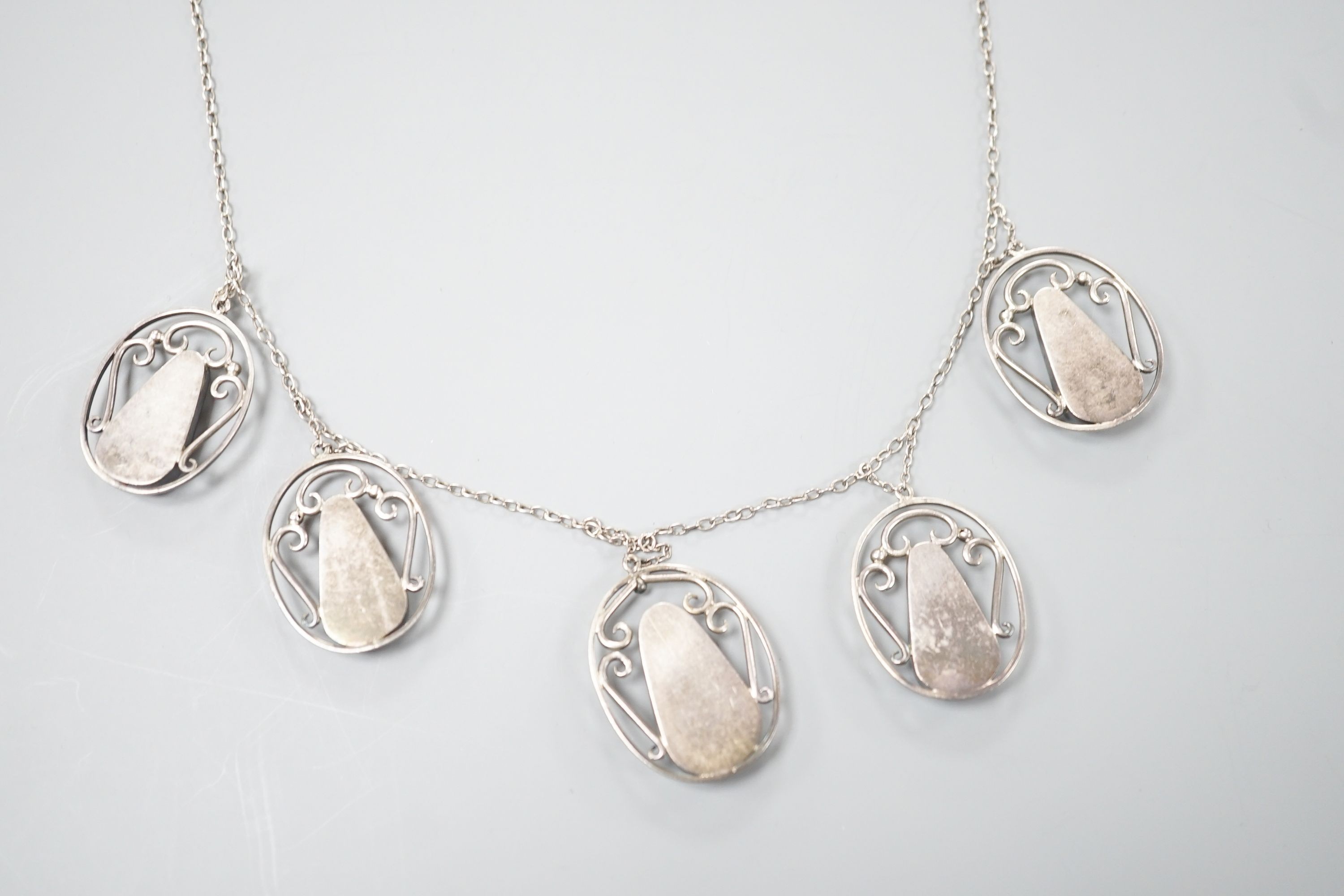 An Arts & Crafts white metal and six stone polychrome enamel set fringe necklace, 52cm.